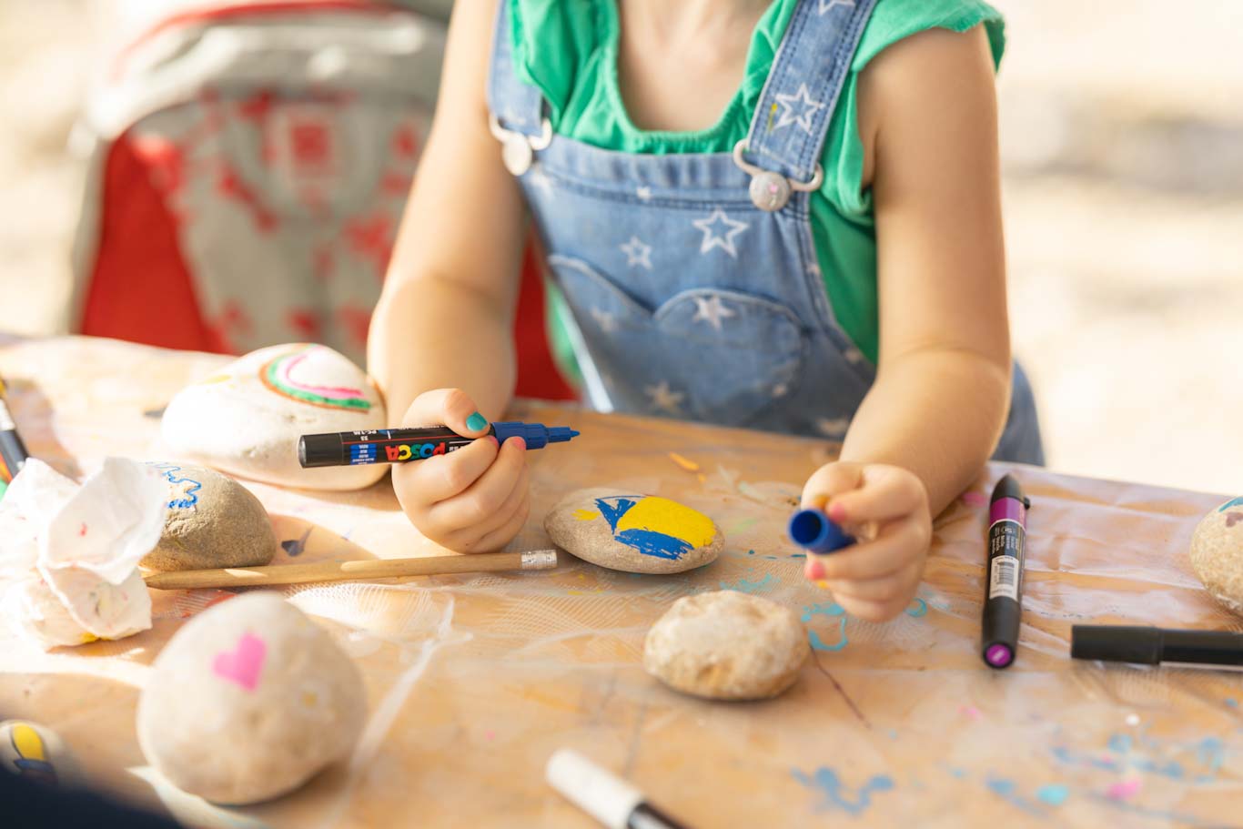 Enfant qui peint sur un galet