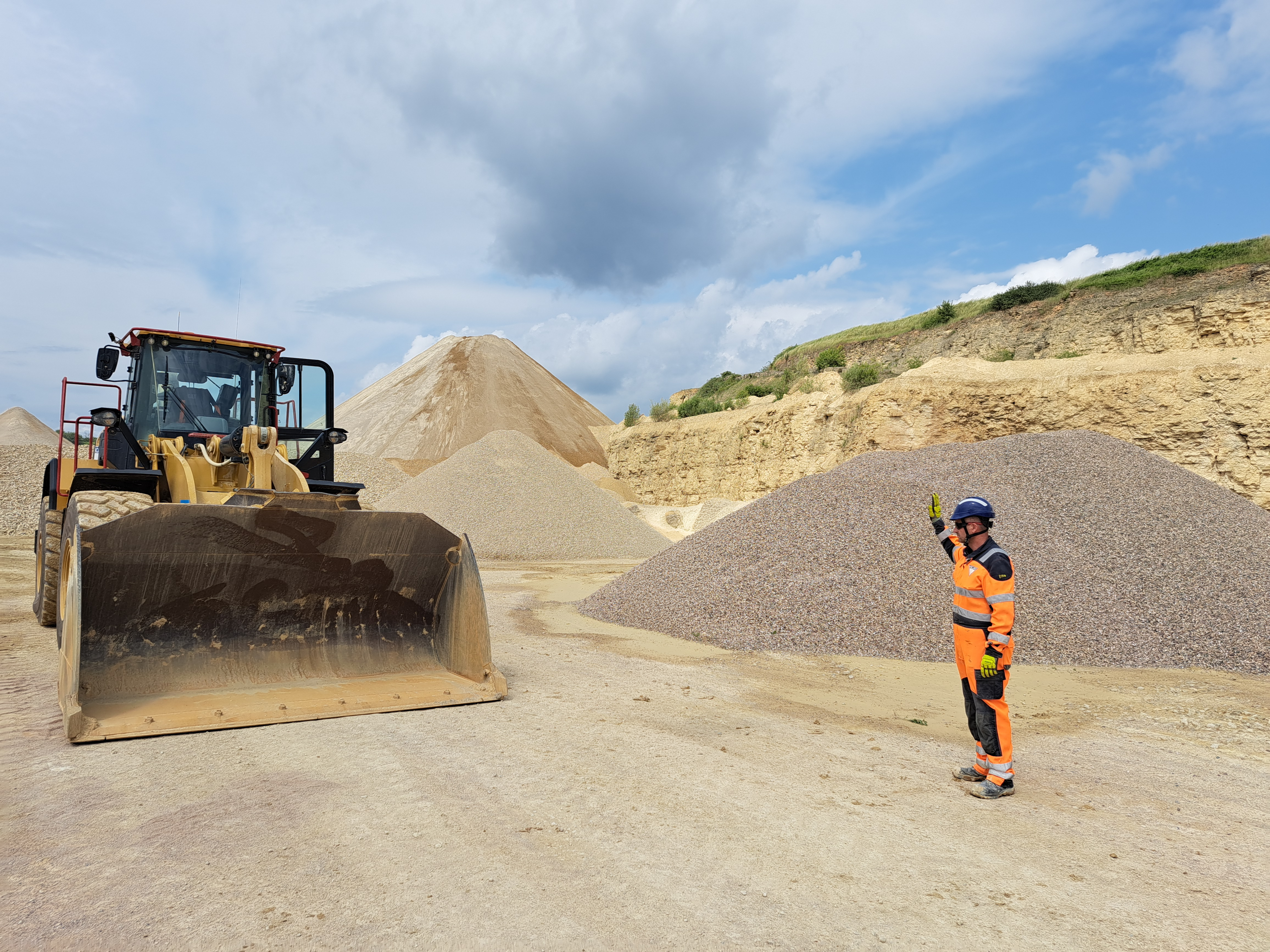 Collaborateur faisant un signe au conducteur d'engin