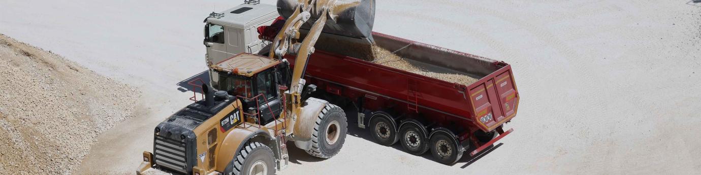 Un chargeur verse des granulats dans un semi-remorque